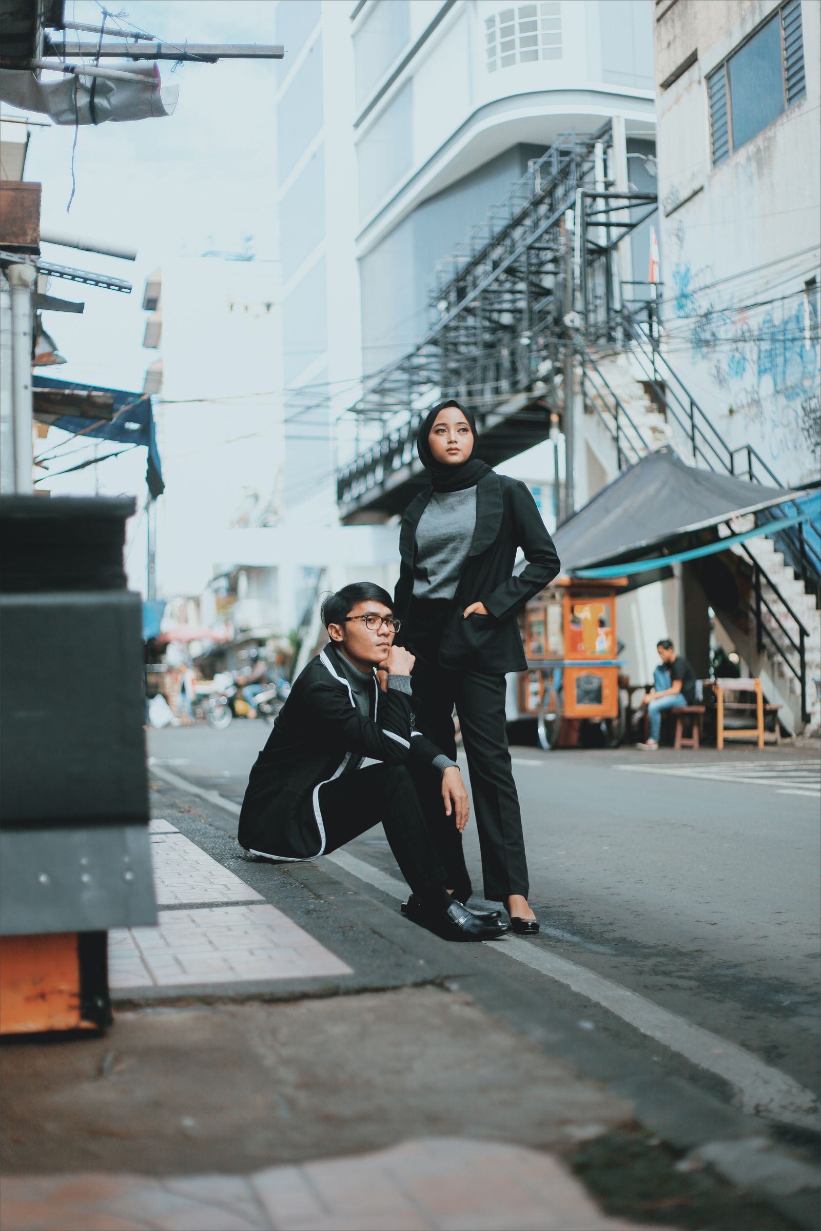 Two people in black outfits in an urban setting