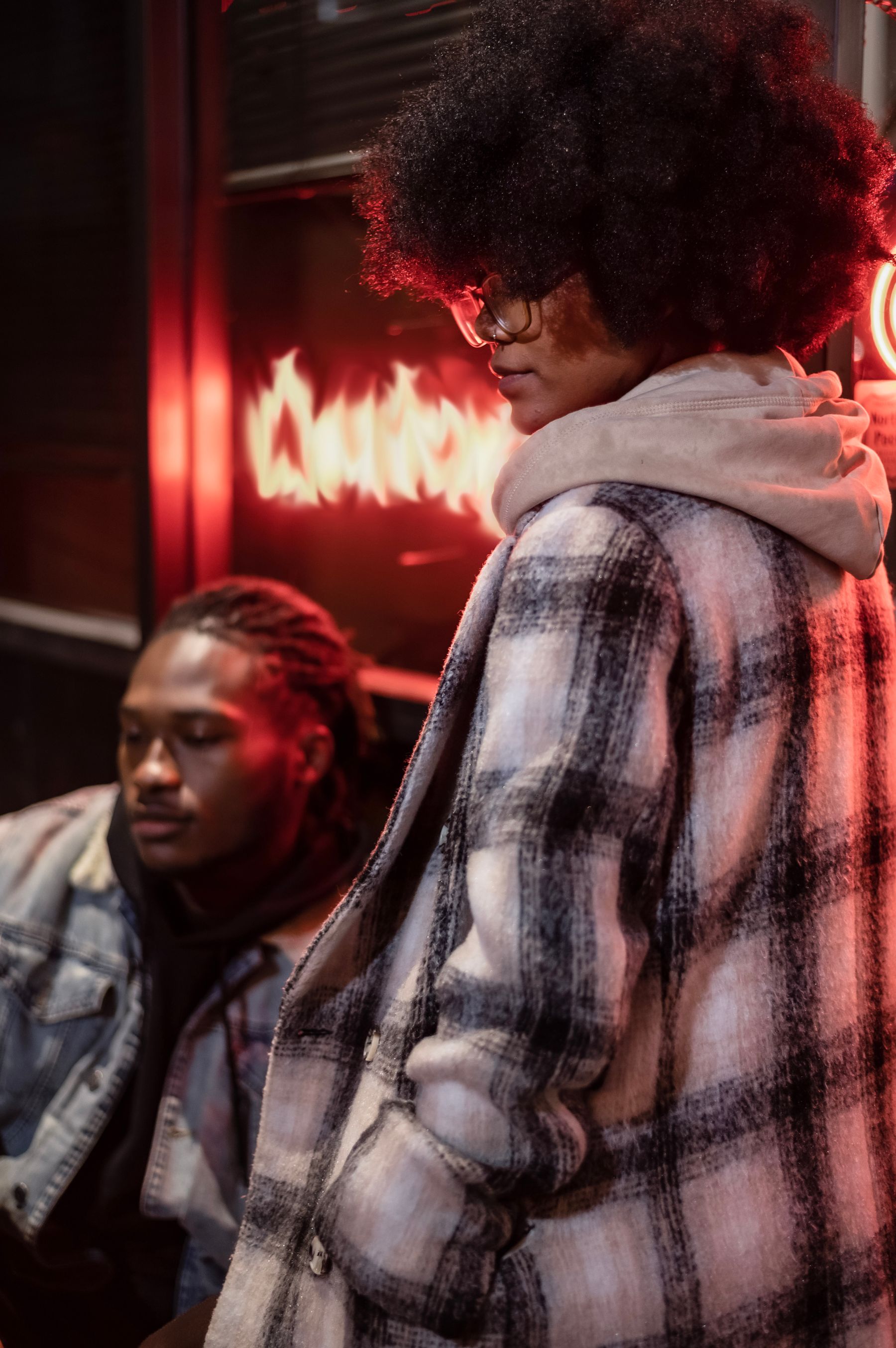 Two friends in streetwear under city lights at night